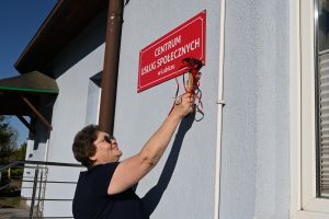 Tablicę przybija Anna Sikorska, dyrektor CUS
