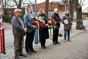 Pod tablicą złożono kwiaty